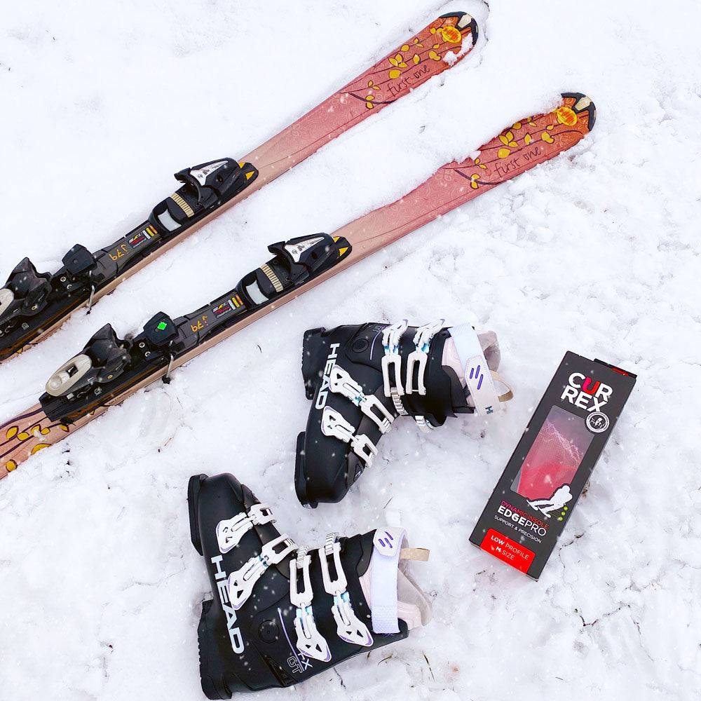 CURREX EDGEPRO low profile insoles laying in the snow next to skis and ski boots #profile_low