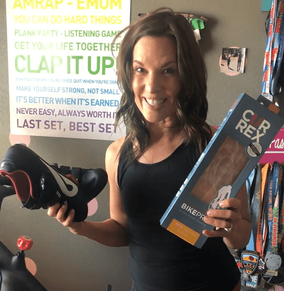 Woman explaining the benefits of the BikePro insoles while bicycling and using Peloton bike.