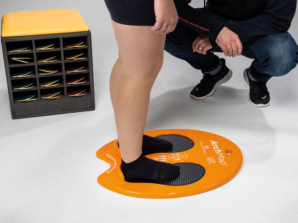 Person using CURREX footdisc to determine arch height and what insoles are needed.