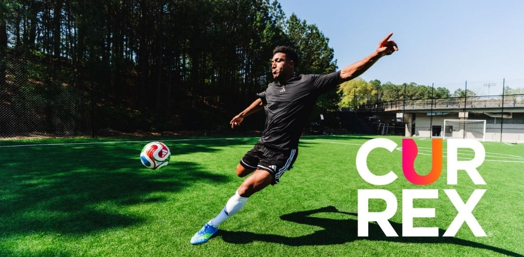 An action shot of a man kicking a soccer ball