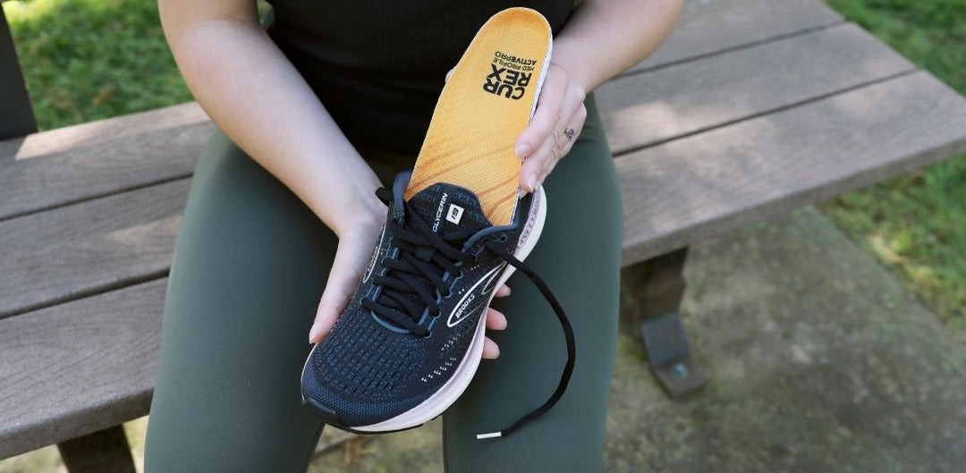 ACTIVEPRO insole being inserted into a black tennis shoe