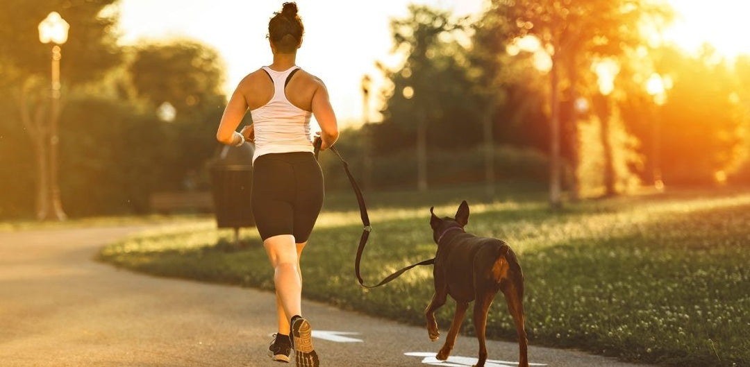 Woman running with a leashed dog