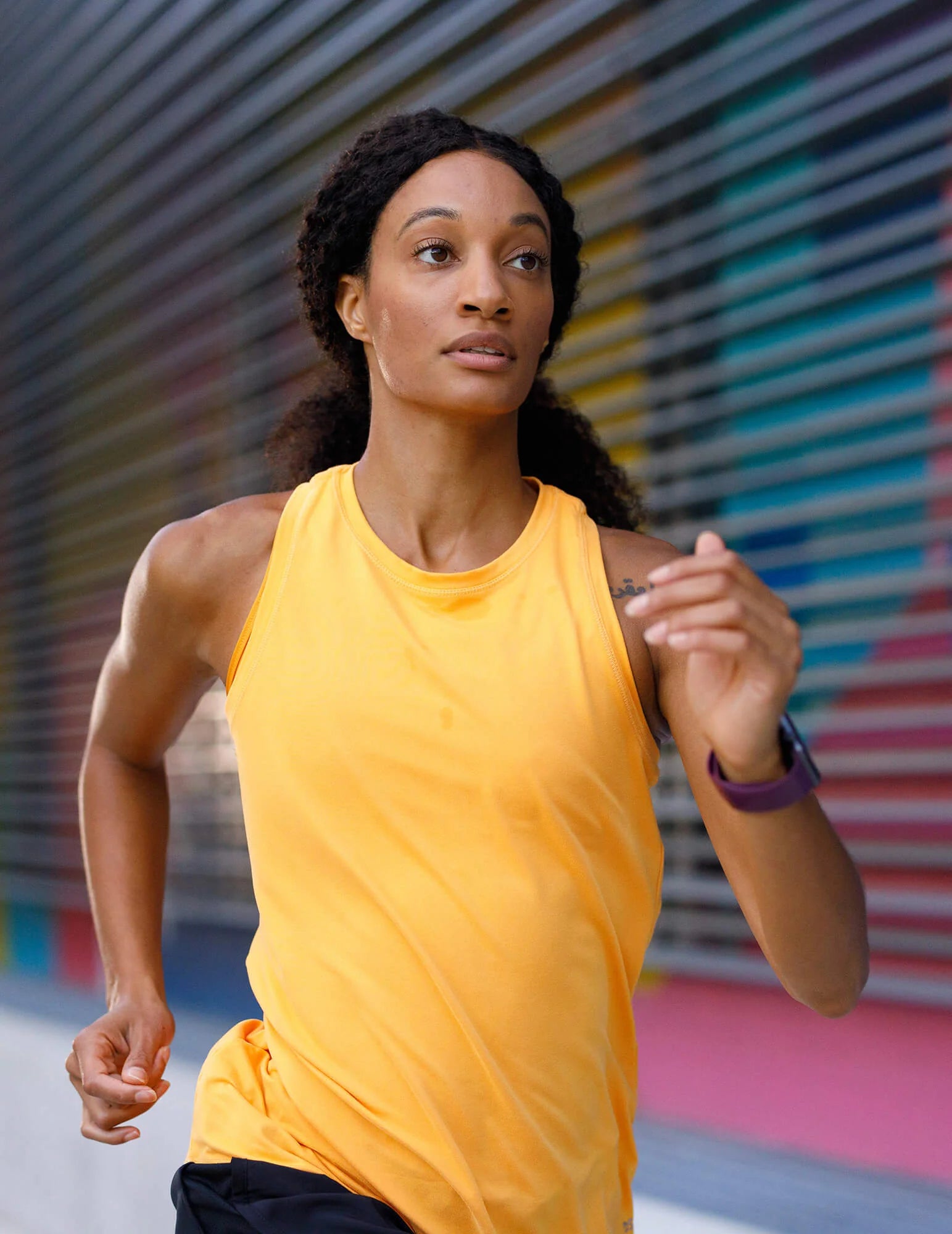Athletic woman running through city