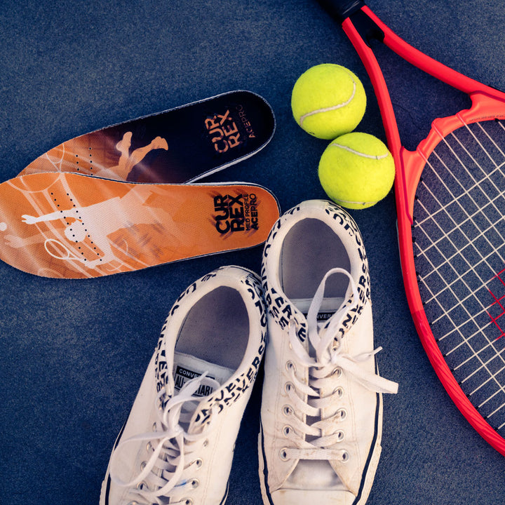 CURREX ACEPRO insoles next to white tennis shoes, yellow tennis balls, and racquet #profile_low