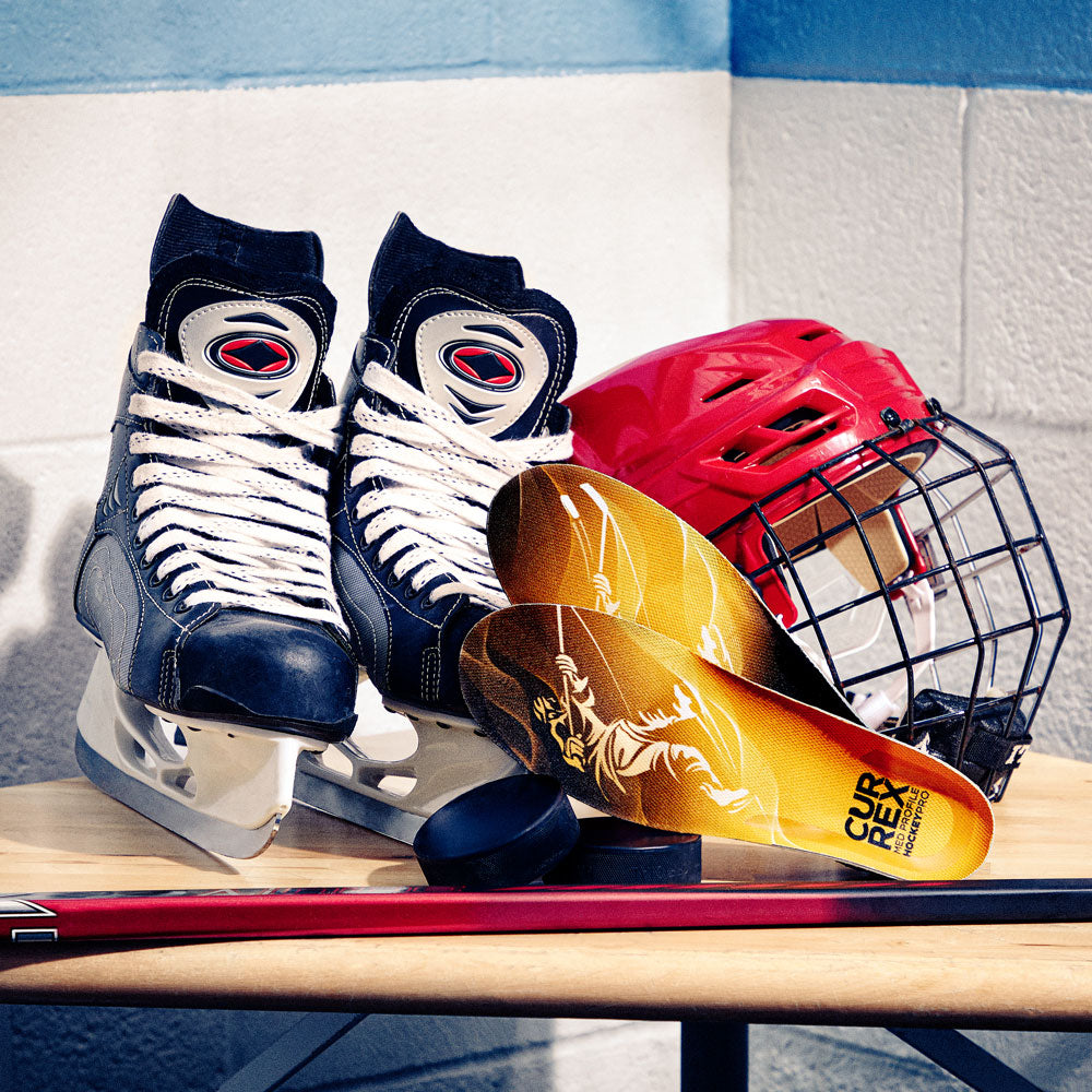 CURREX medium profile HOCKEYPRO insoles next to hockey ice skates, helmet, and hockey stick #profile_medium