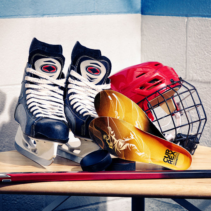 CURREX medium profile HOCKEYPRO insoles next to hockey ice skates, helmet, and hockey stick #profile_high
