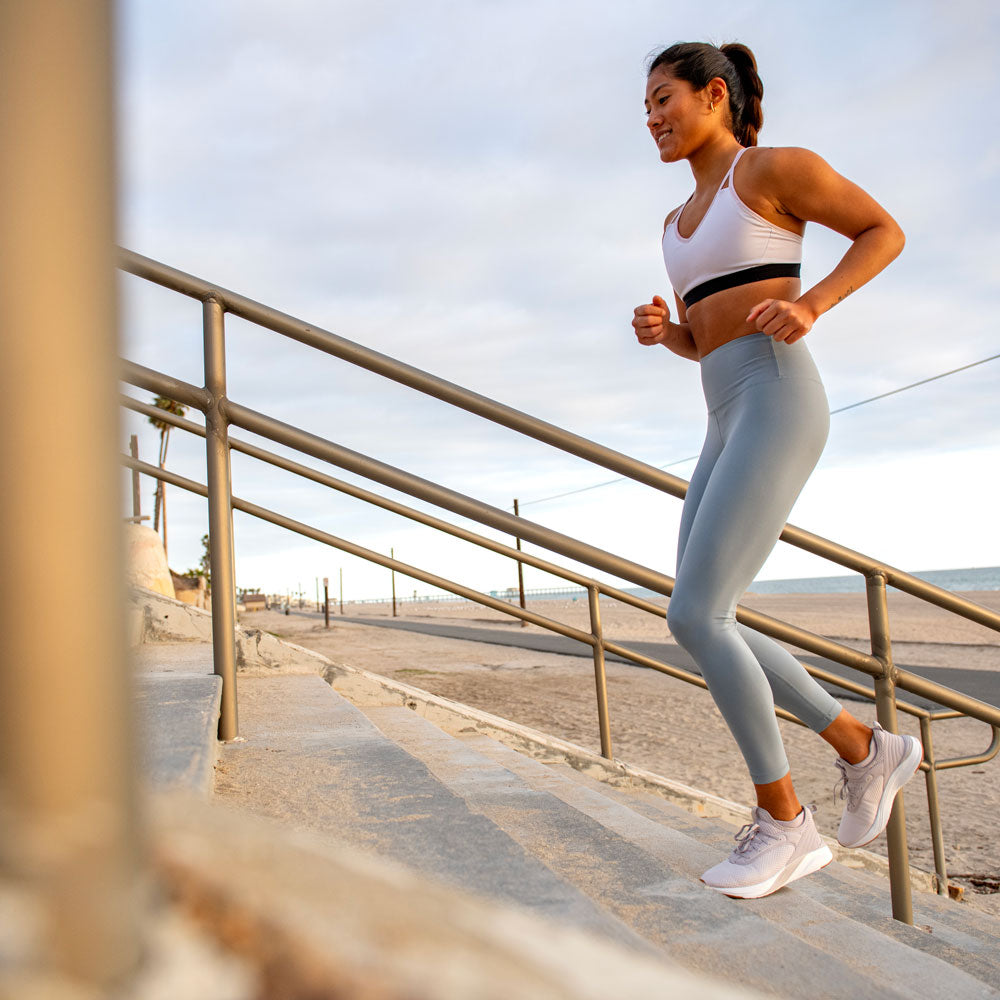 Woman running outdoors up stairs #profile_low