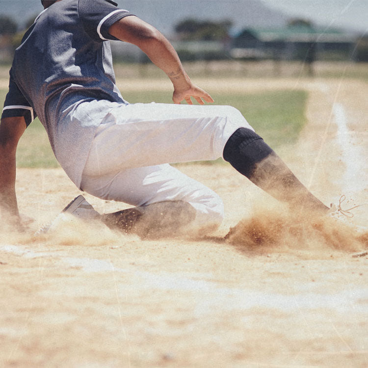 Baseball player sliding into home plate on a baseball field