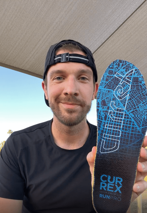 Man holding a pair of Currex RunPro Insoles and explaining the benefits