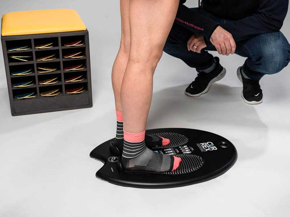 Person using CURREX footdisc to determine arch height and what insoles are needed.