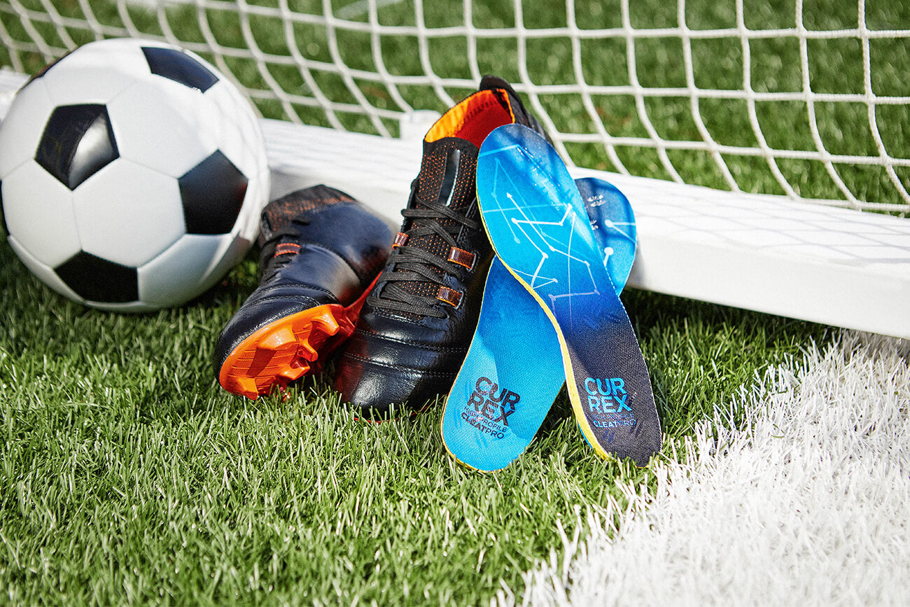 Currex CleatPro insoles on soccer field, soccer ball, cleats