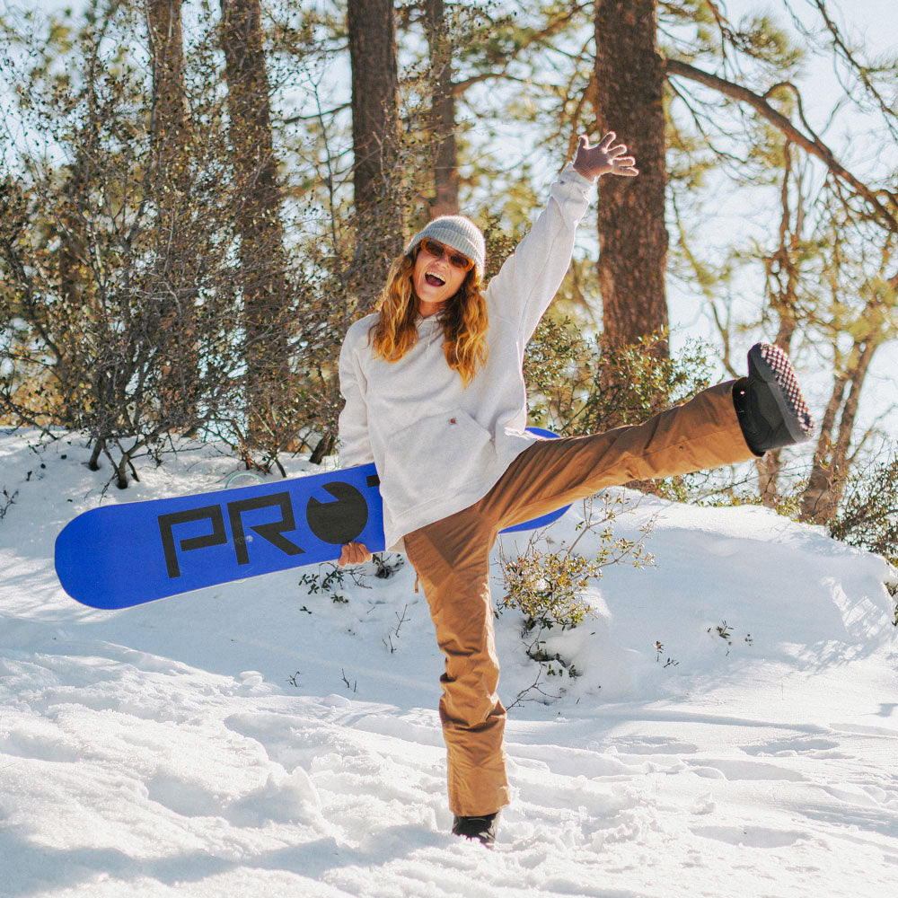 Woman standing in snow excited to go skiing #profile_low