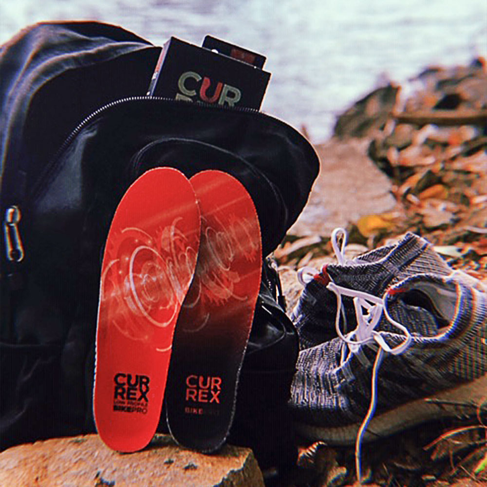 CURREX HIKEPRO red low profile insoles sitting next to hiking shoes and backpack near river #profile_low