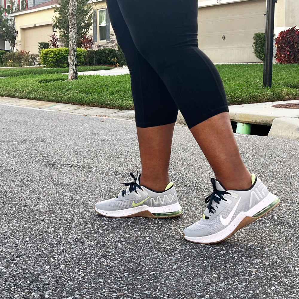 Woman walking down the street while wearing gray sneakers with CURREX METPAD insoles inside #profile_high