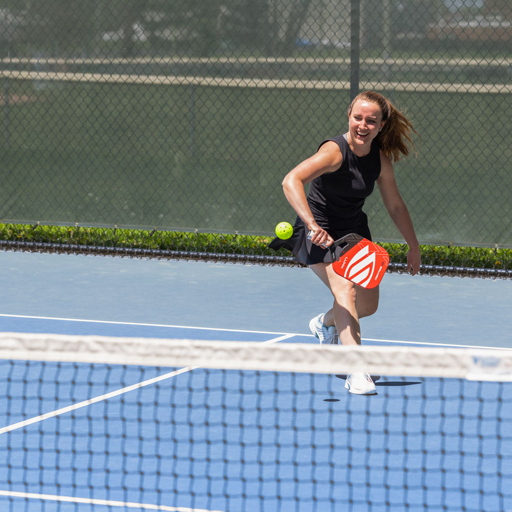 Woman playing pickleball on blue pickleball court #profile_high