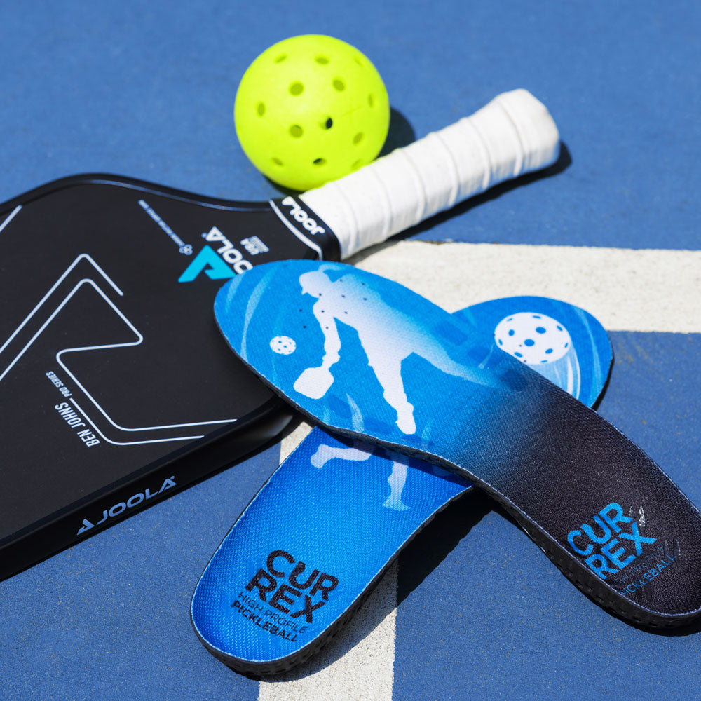 CURREX PICKLEBALLPRO blue high profile insoles sitting next to pickleball gear; pickleball paddles and pickleball ball #profile_high