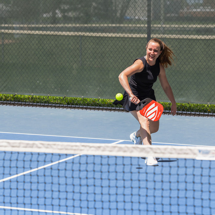 Woman playing pickleball on blue pickleball court #profile_medium