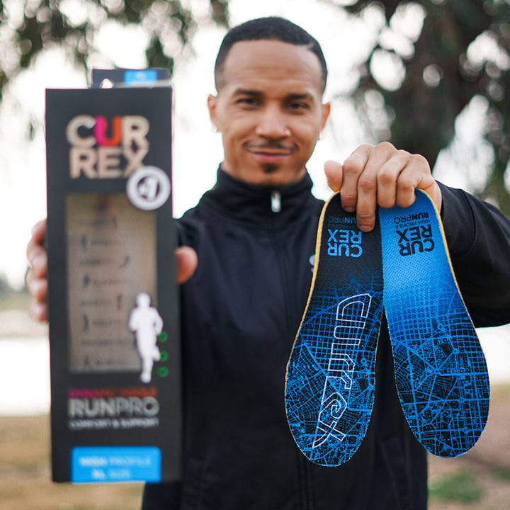 Man holding up a pair of blue high profile CURREX RUNPRO insoles #profile_high