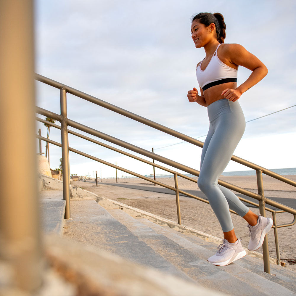 Woman runner taking a break from run while wearing CURREX RUNPRO running insoles #profile_low